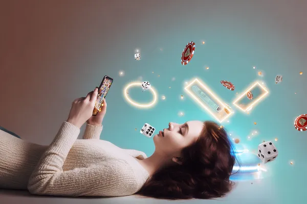 A young woman relaxing with her phone while dynamic casino elements float around her, illustrating the smooth mobile experience offered by the SPINARA app.
