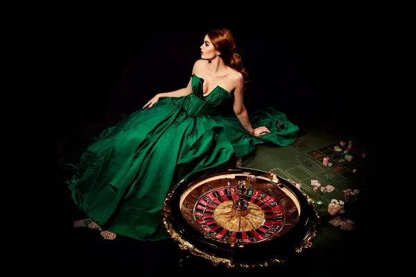 A woman in a luxurious green gown next to an ornate roulette wheel, capturing the upscale casino mood of SPINARA.